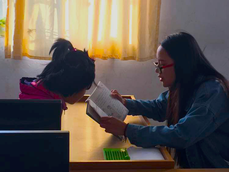 志愿者为视障孩子温习功课 志愿者为视障孩子温习功课